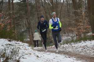 Ein Foto von zwei Teilnehmern der Langstrecke, die dicht hintereinander um eine anteigende Kurve gelaufen kommen.