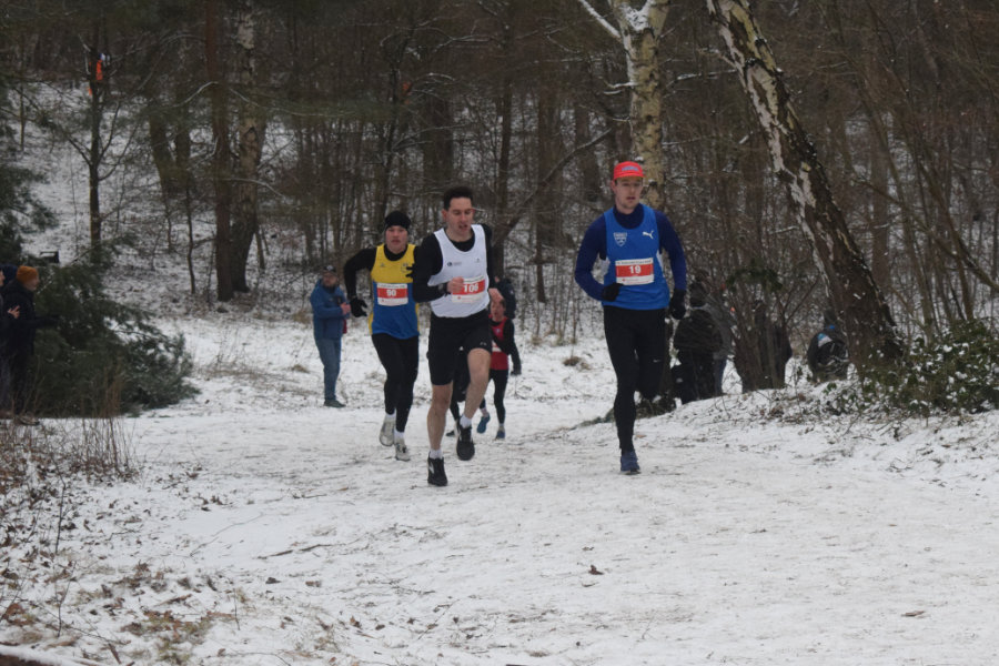 Ein Foto von den drei Führenden der Mittelstrecke, die einen kurzen Anstieg hinauflaufen.
