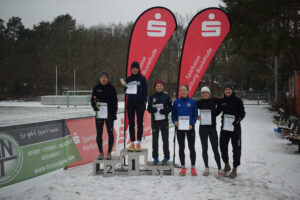 Ein Foto der Siegerehrung der Frauen für die Mittelstrecke. Die ersten drei stehen auf einem Siegertreppchen, die Plätze vier, fünf und sechs rechts daneben.