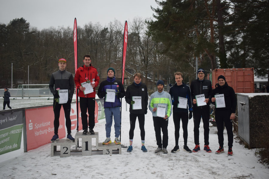 Ein Foto der Siegerehrung der Männer für die Mittelstrecke. Die ersten drei stehen auf einem Siegertreppchen, die Plätze vier bis acht rechts daneben.