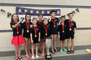 Ein Gruppenfoto des HNT-Teams beim Junior Day 2026, die jungen Schwimmerinnen und Schwimmer haben alle Medaillen um den Hals hängen.