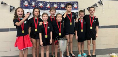 Ein Gruppenfoto des HNT-Teams beim Junior Day 2026, die jungen Schwimmerinnen und Schwimmer haben alle Medaillen um den Hals hängen.