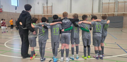 Ein Foto von der 1. E-Jugend der HNT, auf dem die Spieler mit dem Rücken zur Kamera nebeneinander stehen und die Arme um die Schultern des Nebenmannes gelegt haben.