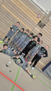 Ein Gruppenfoto von der 1. E-Jugend der HNT beim SVNA-Hallencup, auf dem alle Spieler eine Medaille um den Hals haben; vor ihnen steht der Pokal für den dritten Platz auf dem Boden.