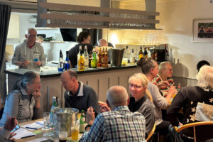 Ein Foto vom Happy-Hours-Event "Cocktails meet soundtracks", das einen großen Teil des Gästeraums sowie die Bar im Hintergrund zeigt.