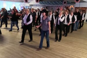 Ein Foto von der HNT Line-Dance-Party, auf dem die Teilnehmenden beim Tanzen zu sehen sind.