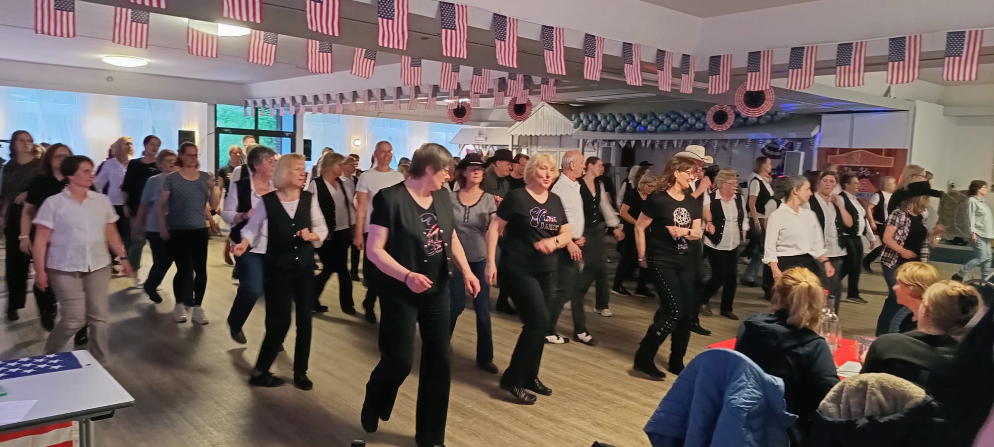 Ein Foto von der HNT Line-Dance-Party, auf dem die Teilnehmenden beim Tanzen zu sehen sind.
