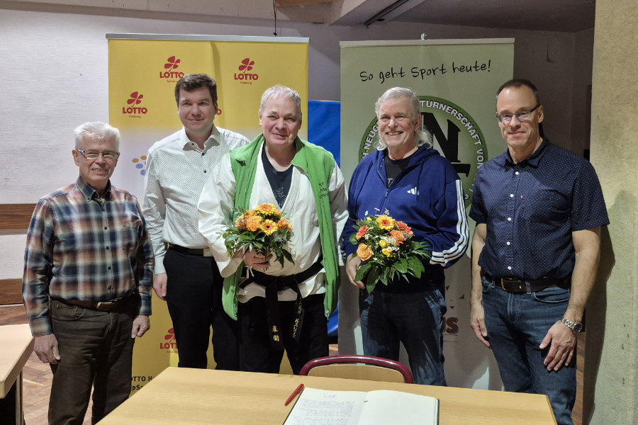 Ein Foto von Michael Richter und Hans Kautz, auf dem beide mit Blumensträußen in den Händen neben den Mitgliedern des HNT-Präsidiums stehen und in die Kamera lächeln.