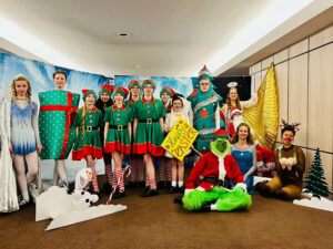 Ein Gruppenfoto der fünfzehn HNT-Tänzerinnen in ihren Kostümen für die Show "A Christmas Spectacular".