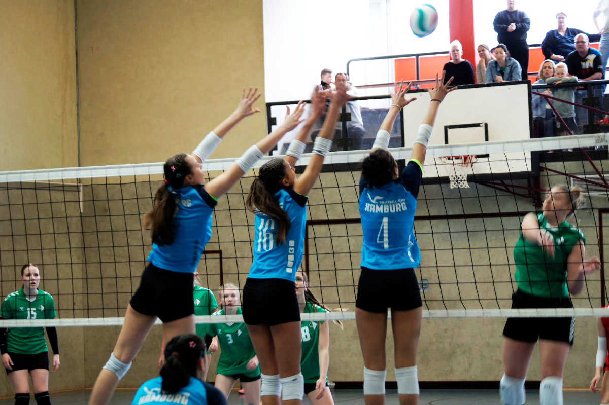 Ein Foto aus einem Spiel der U18 des VTH bei den Norddeutschen Meisterschaften, auf dem drei VTH-Spielerinnen nebeneinander am Netz zum Block hochspringen.