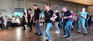Ein Foto der HNT Jolly Boots, die beim „Tanz in den Mai“ der Lucky Liner im Saal zusammen tanzen.
