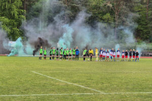Ein Foto, auf dem beide Mannschaften vor dem Spiel nebeneinander auf dem Spielfeld stehen.