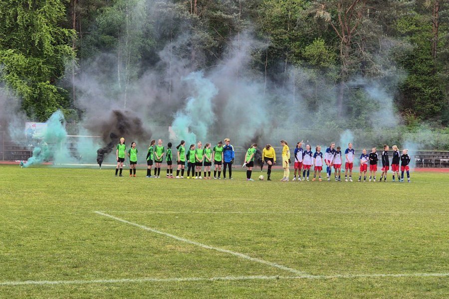 Ein Foto, auf dem beide Mannschaften vor dem Spiel nebeneinander auf dem Spielfeld stehen.