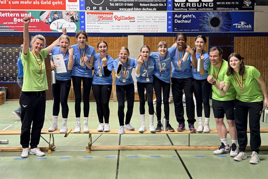 Ein Foto von der Siegerehrung, auf dem die U14-Spielerinnen des VTH nebeneinander auf einer Bank stehen und mit Medaillen um den Hälsen in die Kamera jubeln.