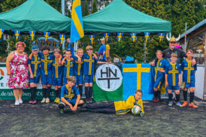 Ein Gruppenfoto der 2. D-Jugend beim Turnier in Hoisdorf, auf dem alle Spieler schwedische Trikots tragen.