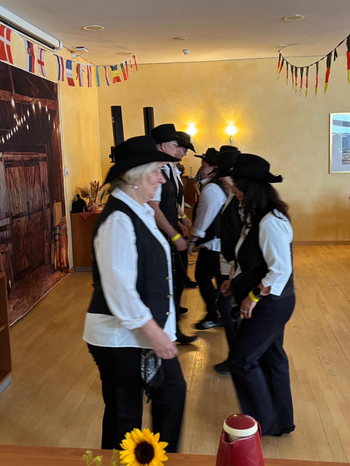Ein Foto von mehreren Mitgliedern der Jolly Boots, die in zwei Reihen nebeneinander tanzen.