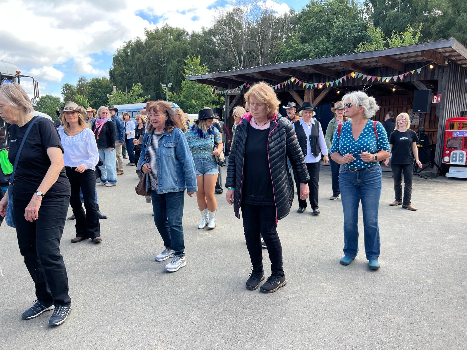 Ein Foto von einigen Besuchern des Countryfests, die Line Dance ausprobieren.