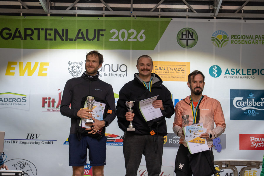Ein Foto der Siegerehrung für den RUHM, auf dem Melvin Siemianowski in der Mitte auf dem Treppchen steht und in die Kamera lächelt.