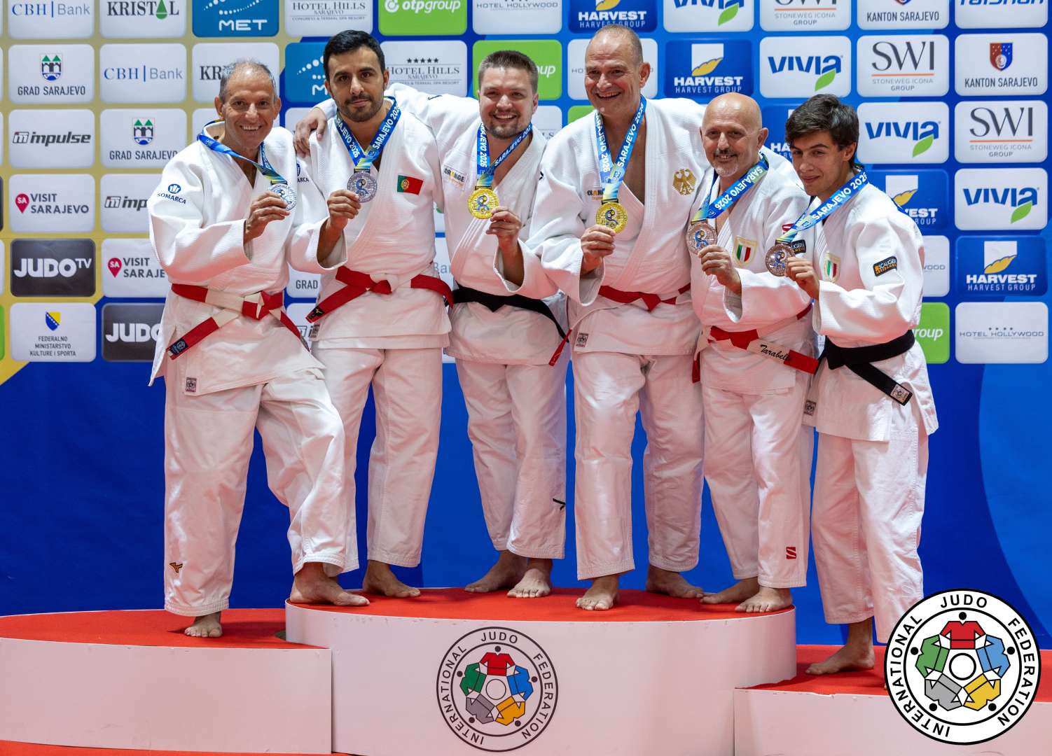Ein Foto von Sönke Schillig und Johannes Kröger bei der Siegerehrung, auf dem sie gemeinsam mit den zweit- und drittplatzierten Judoka ihre Medaillen in Richtung der Kamera halten.